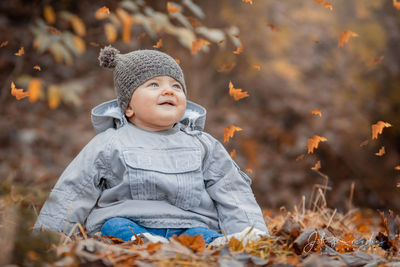 Cute boy looking away on field during autumn