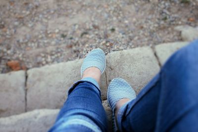 Low section of woman wearing blue shoes standing on floor