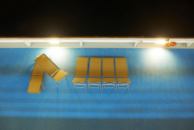 Empty chairs and tables in illuminated room