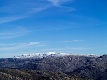 Scenic view of snowcapped mountains against blue sky