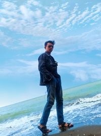 Portrait of man standing on beach against sky