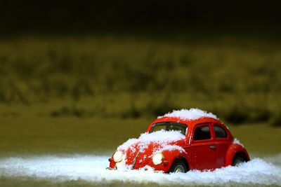 Close-up of red car on snow covered landscape