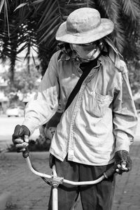 Man wearing mask with equipment standing against tree