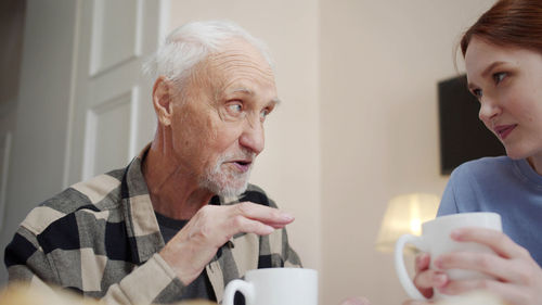 Side view of senior man smoking cigarette at home