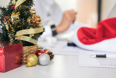 Midsection of business colleagues discussing over graph with christmas decorations on table