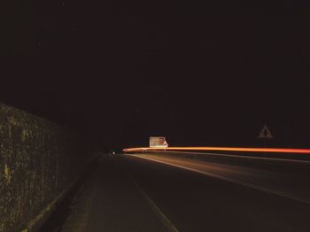 Light trails on road against sky at night