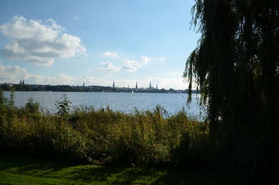 Scenic view of river against cloudy sky