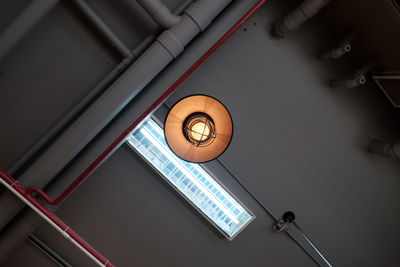 Low angle view of illuminated pendant lights hanging from ceiling