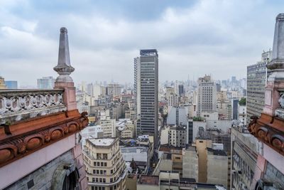 View of cityscape against cloudy sky