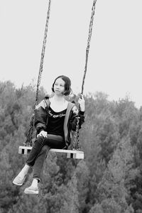 Woman sitting on swing at playground