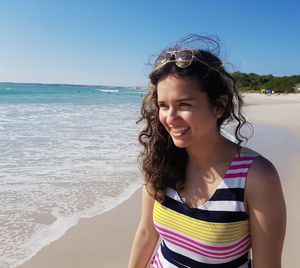 Portrait of smiling young woman standing on beach