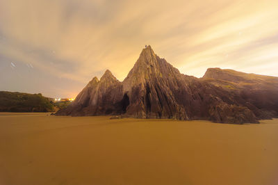 Scenic view of desert against sky during sunset