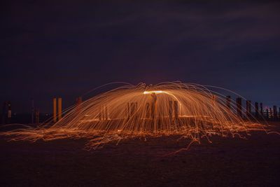 Light trails on field against sky at night