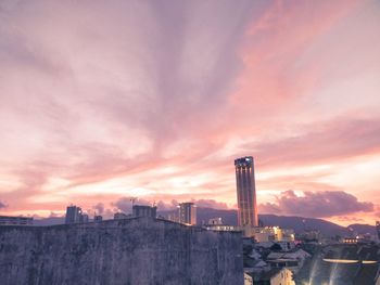 Buildings in city against sky during sunset