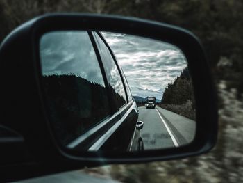 Reflection of sky on side-view mirror of car