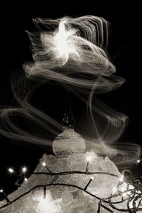 Low angle view of illuminated lighting equipment at night