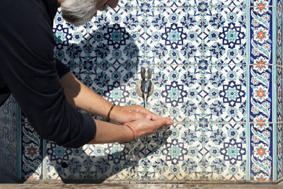 Midsection of woman standing by wall