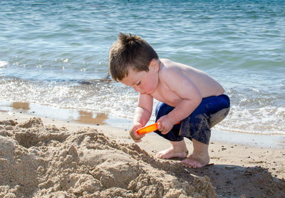 Toddler digging in the sand on a beach vacation