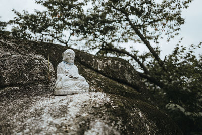 Low angle view of statue against rock