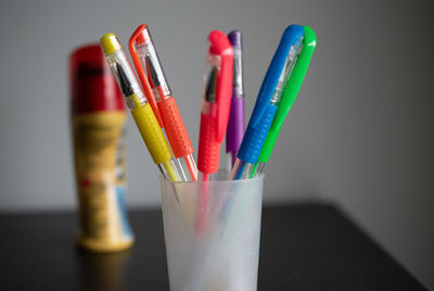 Close-up of colorful pens in container on table
