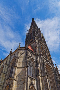 Low angle view of spire of st lambert's church against blue sky