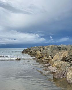 Rocks on beach against sky