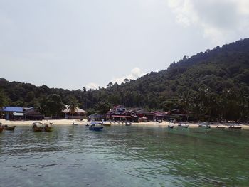 Scenic view of river by buildings against sky