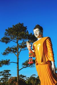 Low angle view of statue against blue sky