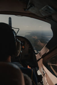 Rear view of man seen through airplane window