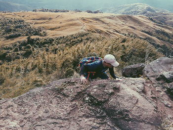 People on rocks against mountains