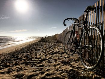 Bicycle at beach against sky