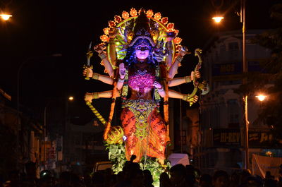 Low angle view of goddess statue on street at night