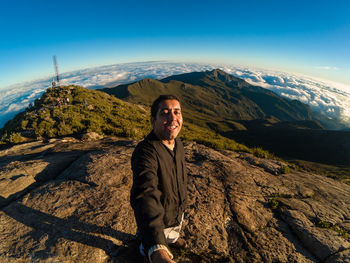 Portrait of smiling mid adult man standing on mountain