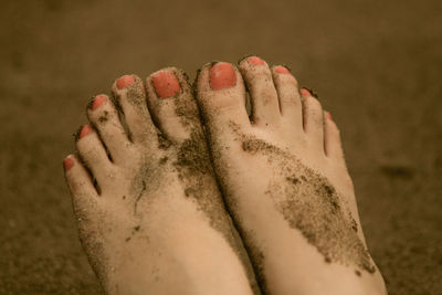 Low section of woman relaxing on sand at beach