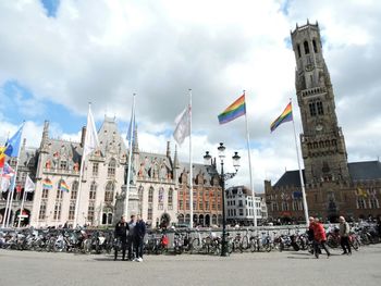 People at town square against cloudy sky