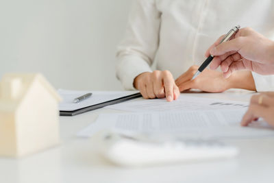 Midsection of woman holding umbrella on table