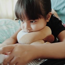 Portrait of cute boy sitting on bed