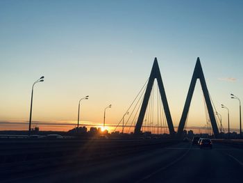 Cars on road against sky during sunset