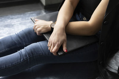 Low section of woman sitting on sofa