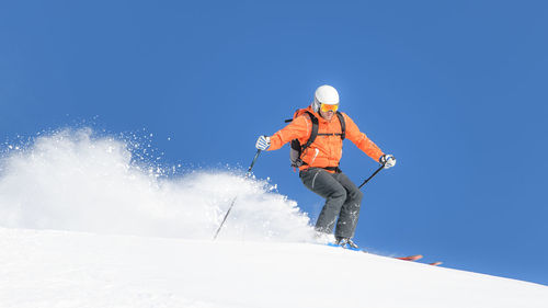 Low angle view of man skiing on snow covered landscape