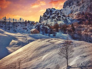 Scenic view of snow covered mountains against sky during sunset