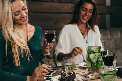 Happy young woman drinking glasses on table