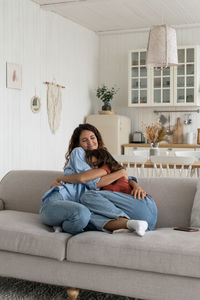 Loving mother hugging embracing with teenage daughter at home, healthy parent-child relationship