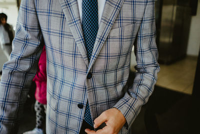 Midsection of businessman in checked pattern suit