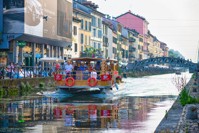 Boats in canal amidst buildings in city