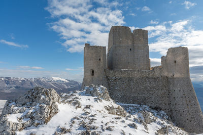 Built structure on snowcapped mountain against sky