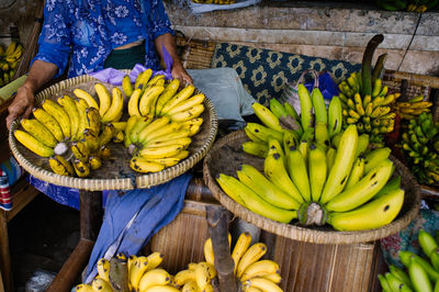 Midsection of woman selling bananas in market
