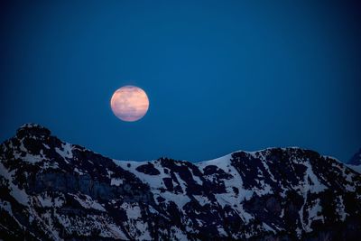 Scenic view of snowcapped mountains against sky at night