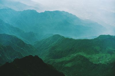 Scenic view of green mountains during foggy weather