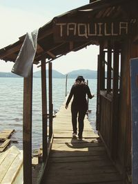 Woman standing on pier at sea